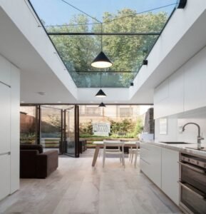 Scandinavian minimalist kitchen with white MDF cabinets, a skylit atrium, and black metal accents.