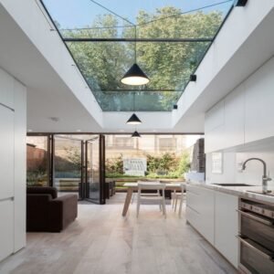 Scandinavian minimalist kitchen with white MDF cabinets, a skylit atrium, and black metal accents.