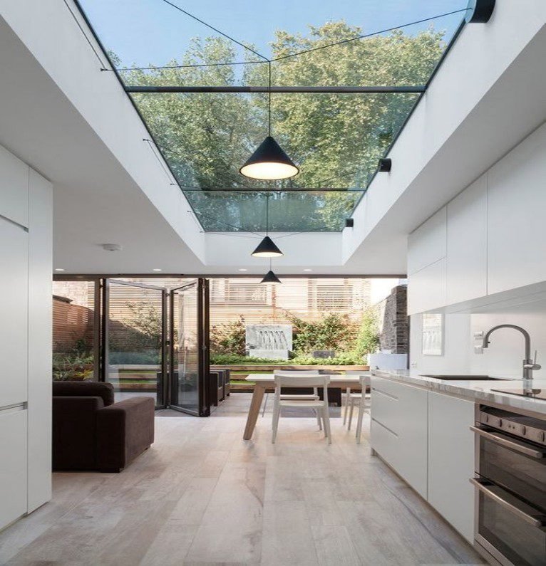 Scandinavian minimalist kitchen with white MDF cabinets, a skylit atrium, and black metal accents.