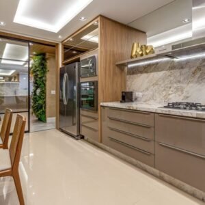 Light luxury kitchen with wood accented taupe cabinets marble backsplash and mirrored accents.