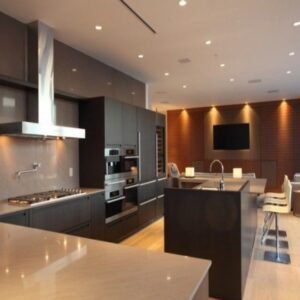 High-end luxury kitchen with dark gray cabinets wood accents and integrated appliances.