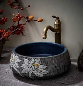 Lotus Patterned Ceramic Basin boasts floral motifs, deep blue finish, creates traditional ambiance in bathrooms with its ceramic craftsmanship and cultural details.
