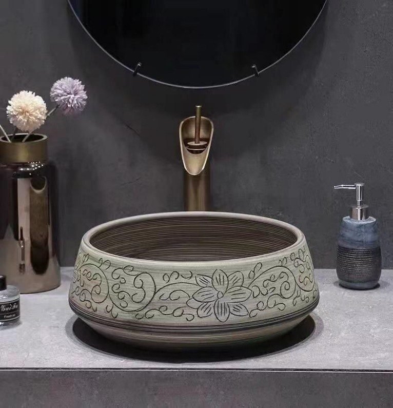 Floral Engraved Ceramic Basin displays delicate carvings, muted tones, adds classic charm to bathrooms with its ceramic artistry and timeless design.