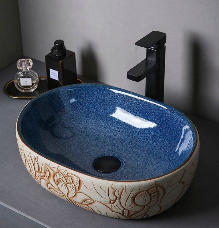 Lotus Carved Ceramic Basin boasts 3D carvings, dual-tone finish, creates oriental ambiance in bathrooms with its ceramic artistry and cultural details.