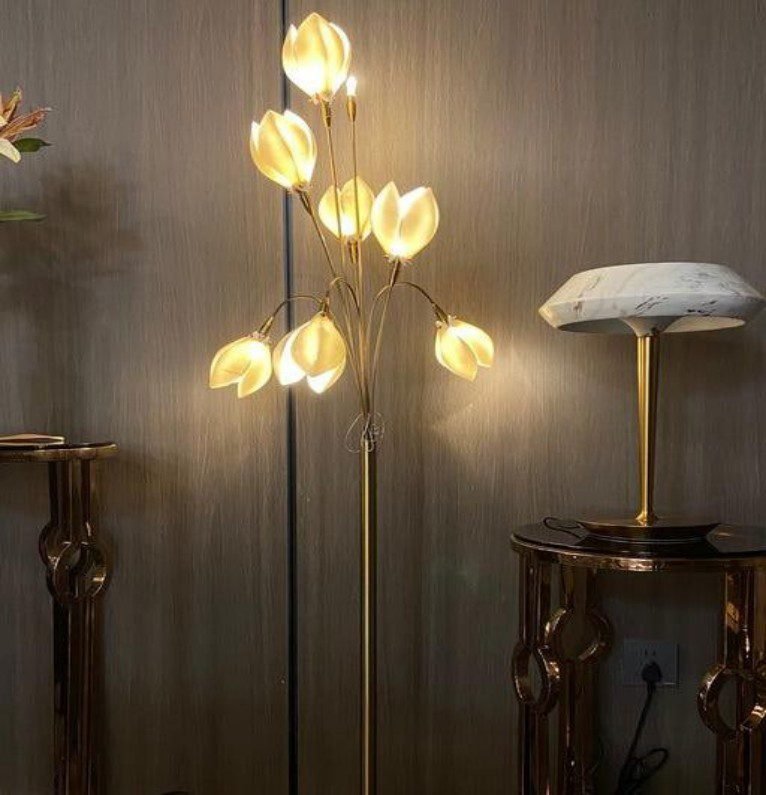 Adorned with golden magnolia flower designs, this floor lamp emits soft warm light, bringing a romantic elegant touch to classic or luxury living spaces.