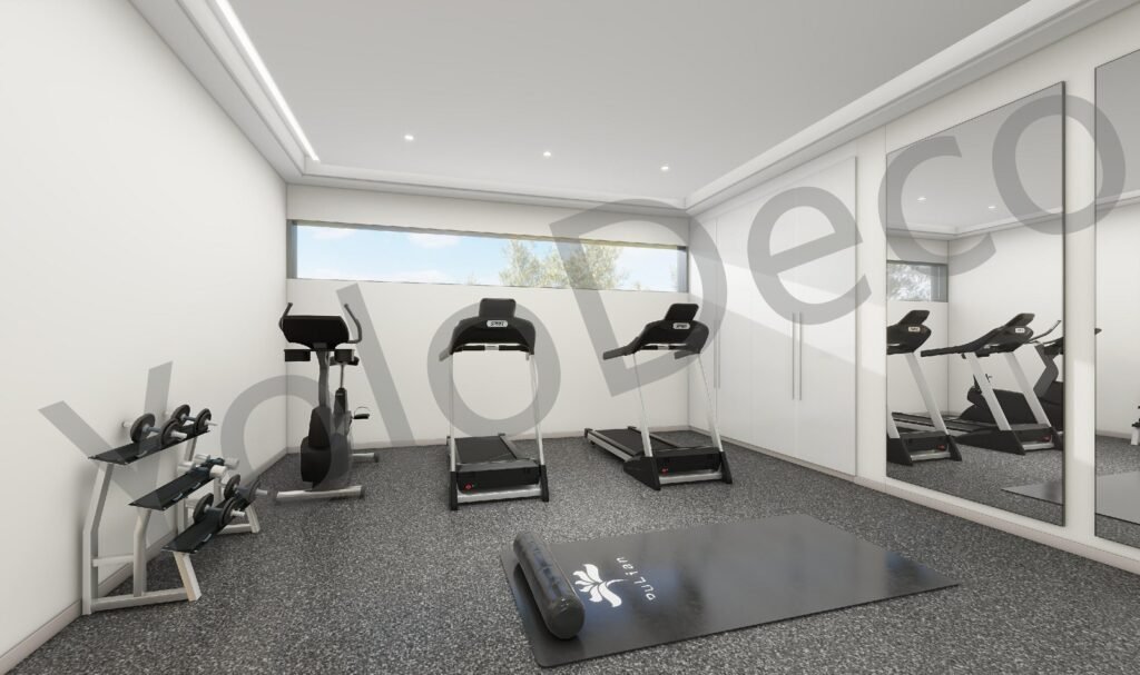 Home gym interior design in Grindana villa with treadmills, grey flooring, and full-length mirror wall.