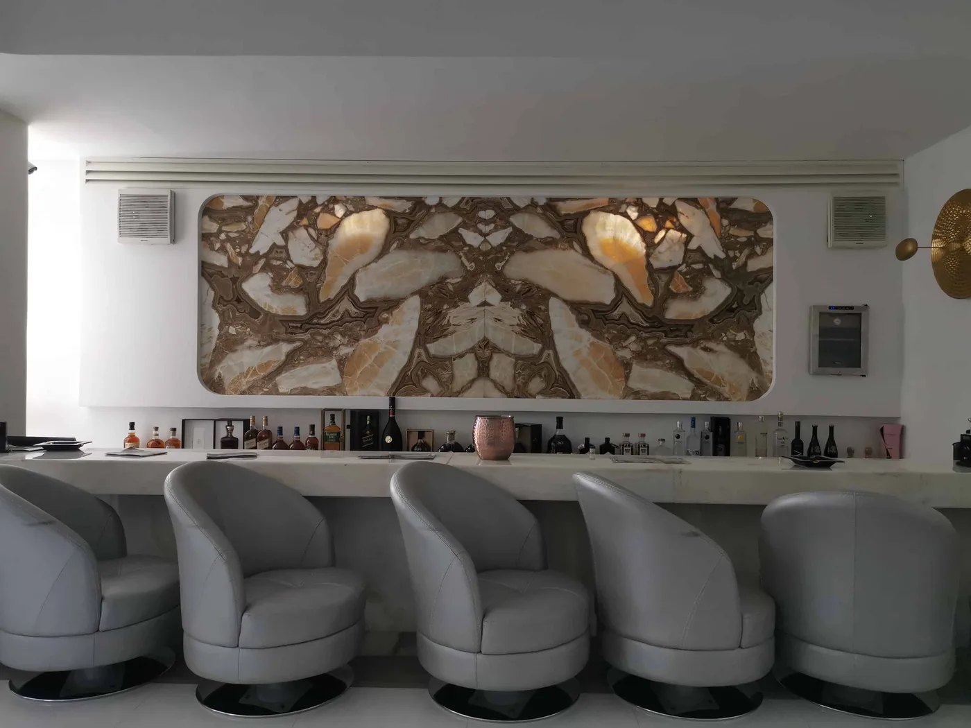 Bar chairs installed at a stone-clad bar counter