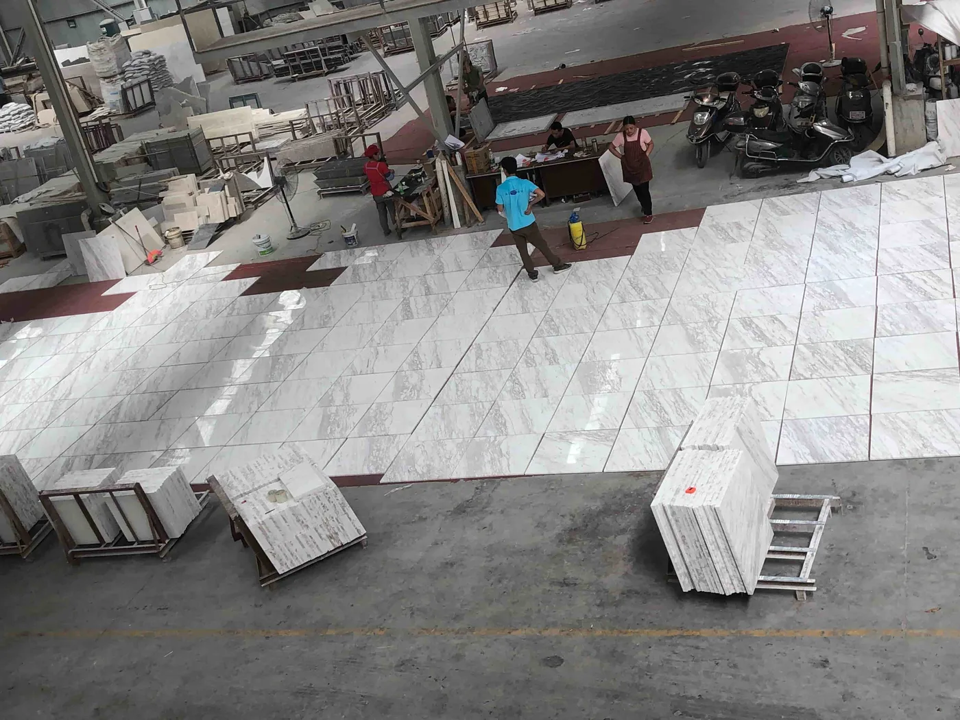 White marble-effect tiles dry-laid in the workshop for layout checking