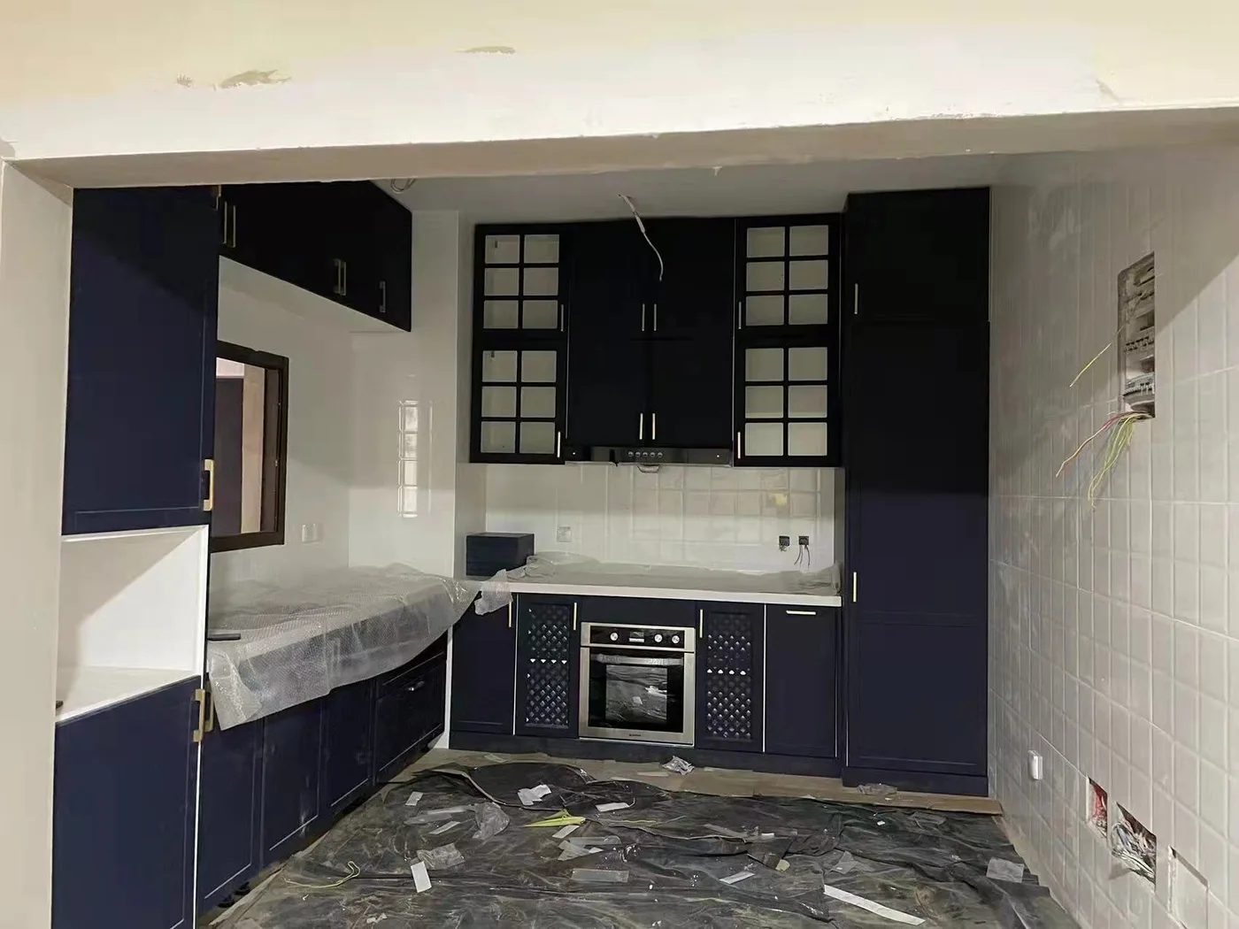 Navy kitchen cabinets being fitted on site
