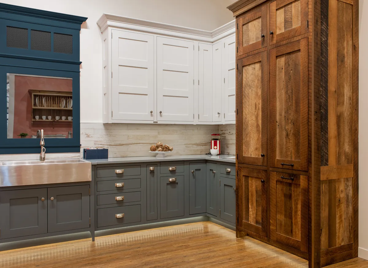 Crown Point Cabinetry showroom kitchen with inset cabinets and a reclaimed-wood tall cabinet