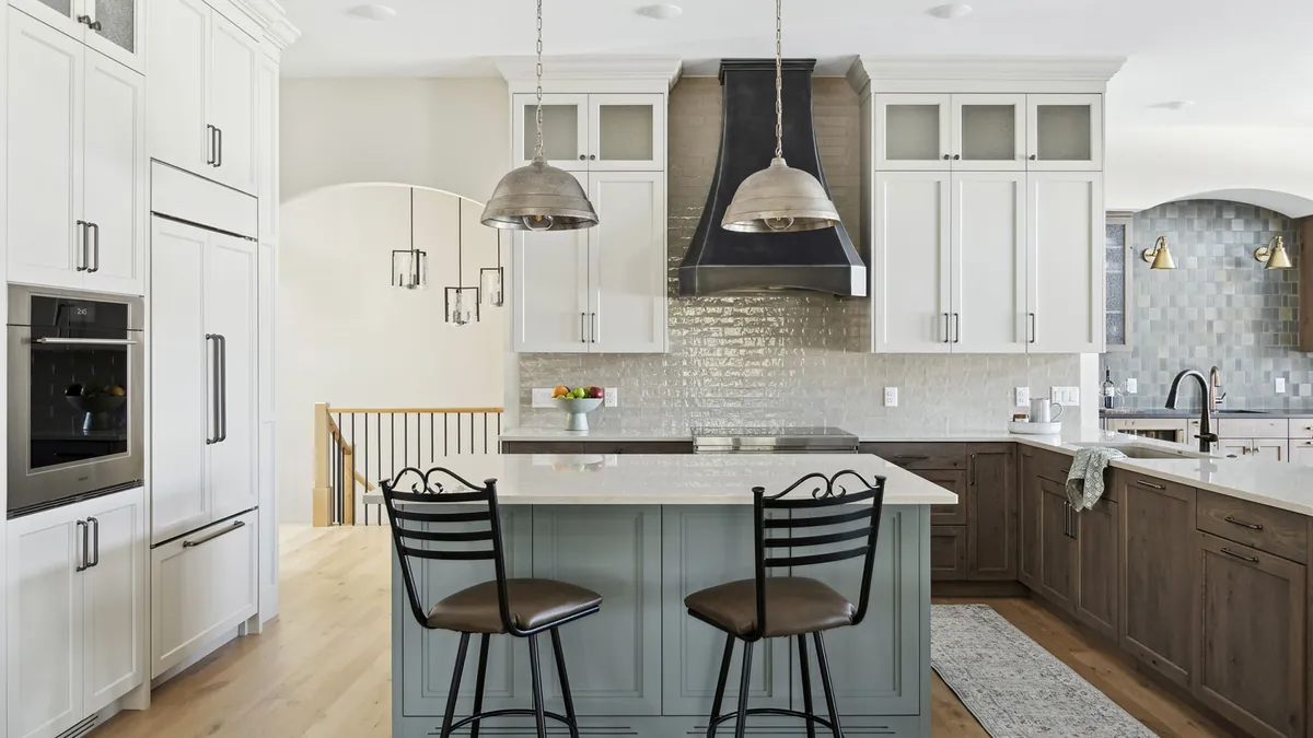 Plato Woodwork custom kitchen with white and stained wood cabinetry and black range hood