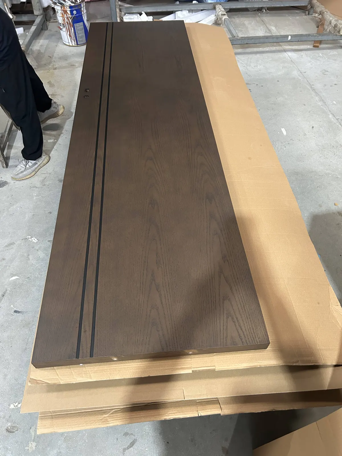 Wood-finish panel inspected before furniture assembly