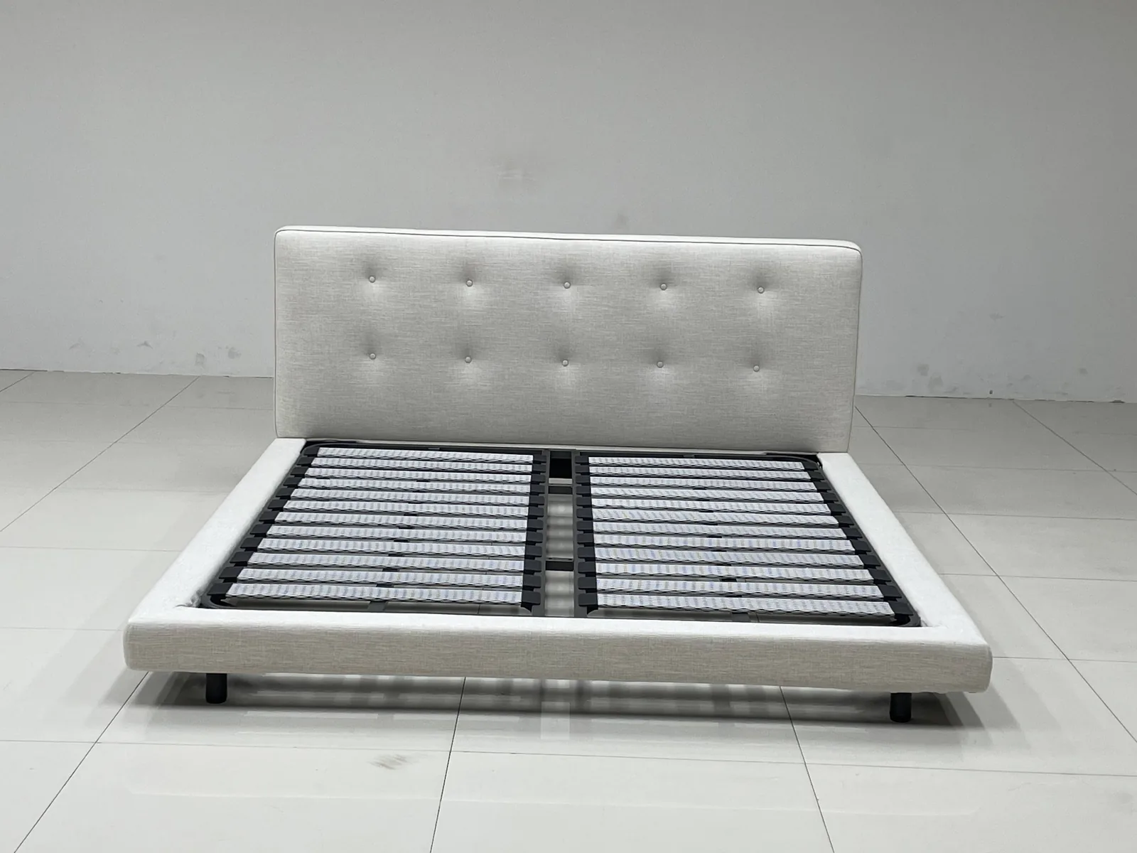 Upholstered bed frame with slat system assembled for function and assembly inspection