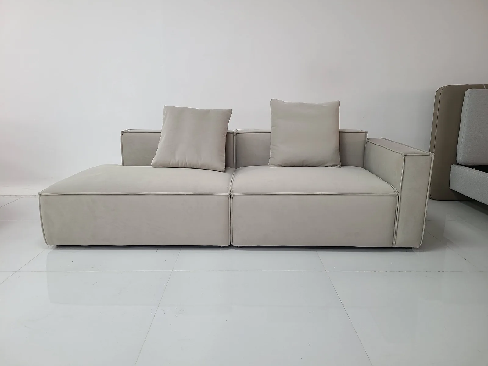 Light fabric sofa staged for upholstery and stitching inspection before export packing